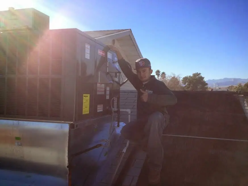 HVAC technician performing Heat Pump Repair on a rooftop unit in Yukon